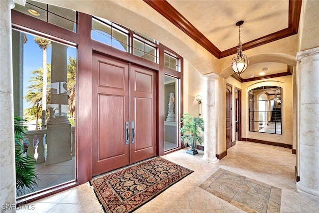 foyer with decorative columns and crown molding