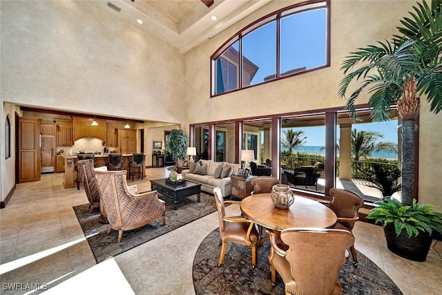 dining space with light tile patterned floors and a high ceiling