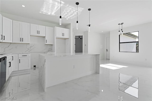 kitchen featuring hanging light fixtures, a kitchen island, light stone counters, backsplash, and white cabinets