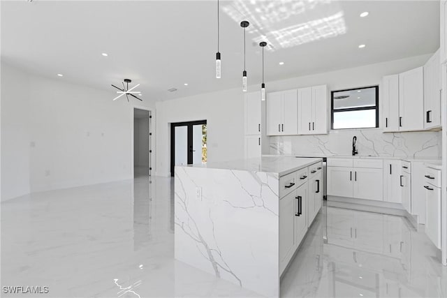 kitchen featuring white cabinets, a center island, and a chandelier