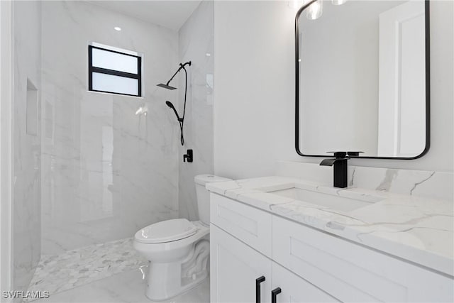 bathroom featuring tiled shower, vanity, and toilet