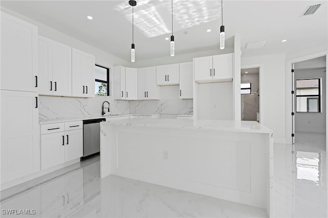 kitchen with a kitchen island, light stone counters, stainless steel dishwasher, pendant lighting, and white cabinets