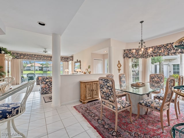 tiled dining space featuring ceiling fan with notable chandelier