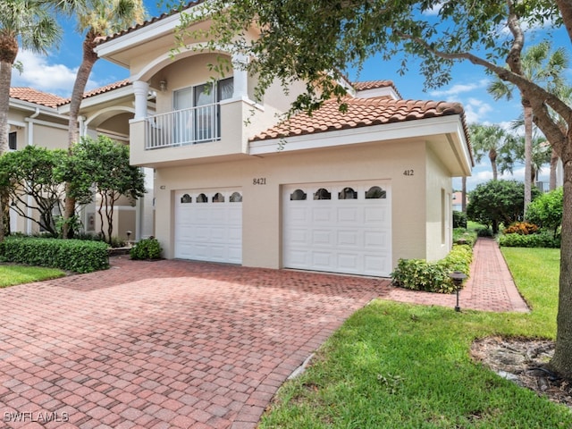 mediterranean / spanish-style house featuring a garage and a balcony