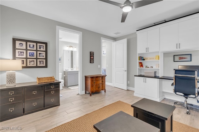 office area featuring built in desk, light hardwood / wood-style floors, and ceiling fan