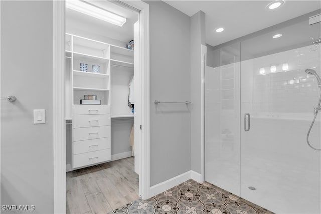 bathroom featuring wood-type flooring and a shower with shower door