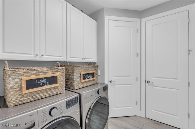 laundry area with light hardwood / wood-style floors, cabinets, and separate washer and dryer