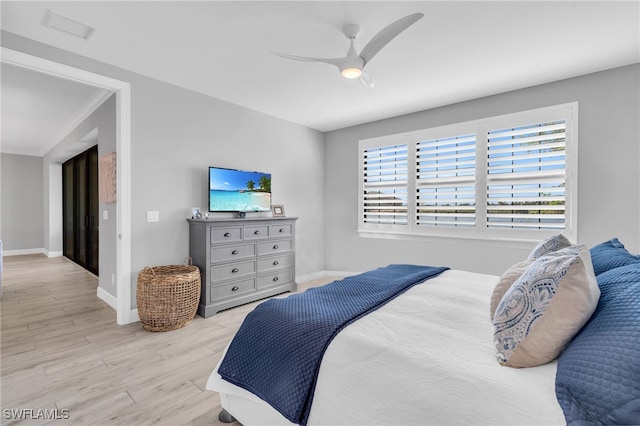 bedroom featuring light hardwood / wood-style floors, ceiling fan, and ornamental molding