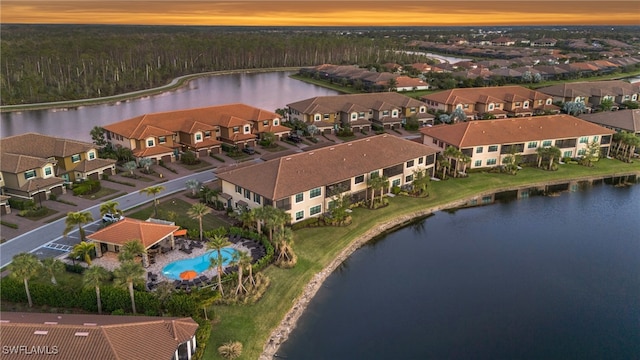 aerial view at dusk featuring a water view