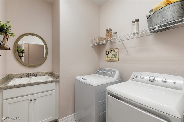 laundry room with washing machine and dryer, sink, and cabinets