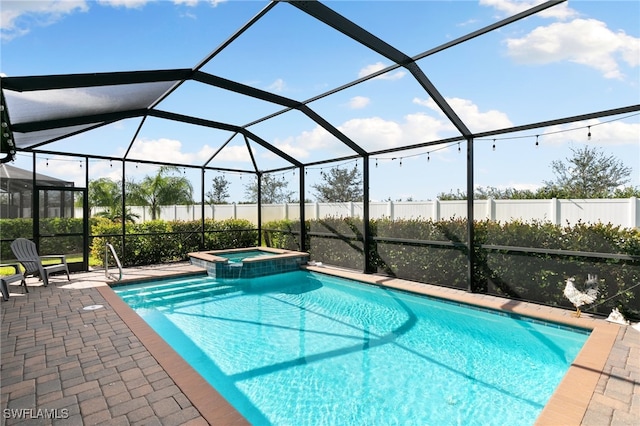 view of pool featuring a lanai, an in ground hot tub, and a patio