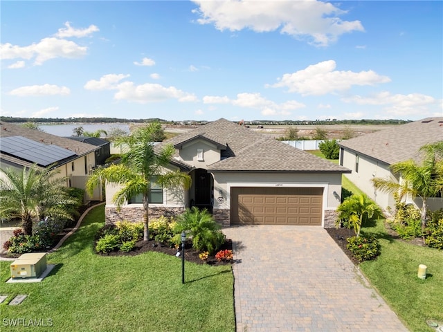 view of front of home with a water view, a front yard, and a garage