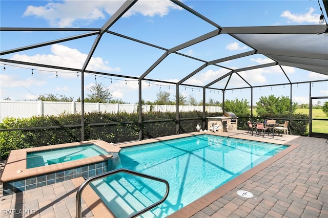 view of swimming pool with glass enclosure, an in ground hot tub, and a patio