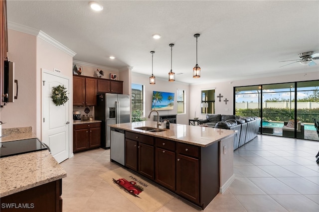 kitchen featuring dark brown cabinetry, sink, stainless steel appliances, hanging light fixtures, and light stone counters