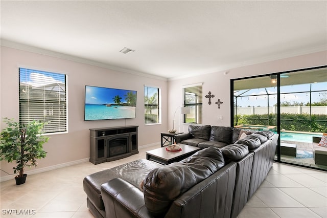 living room featuring light tile patterned floors, plenty of natural light, and crown molding