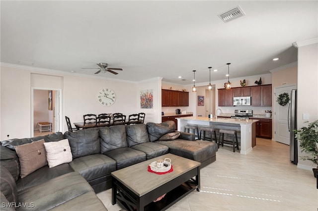 living room with ceiling fan, sink, and ornamental molding