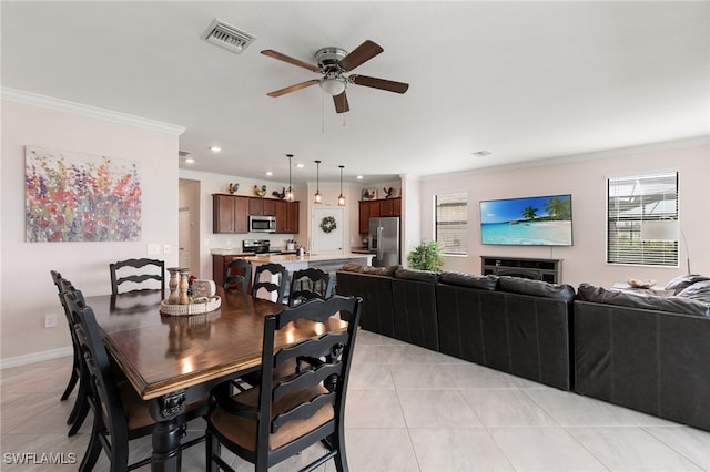 tiled dining area featuring crown molding and ceiling fan