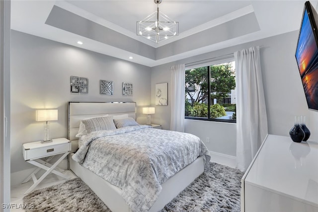 bedroom featuring a chandelier and a raised ceiling