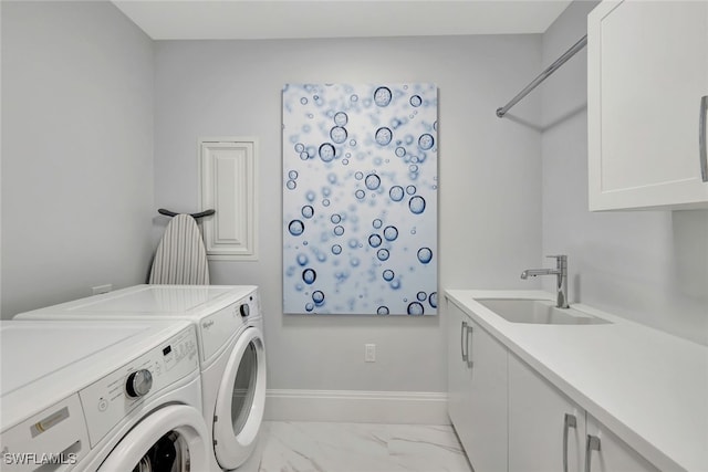 laundry room featuring washing machine and dryer, sink, and cabinets