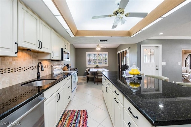 kitchen with tasteful backsplash, visible vents, a raised ceiling, appliances with stainless steel finishes, and a sink