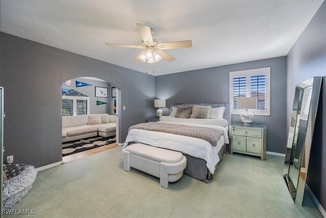 27790 Hacienda E Blvd Unit 206B, Bonita Springs, FL 34135 - carpeted bedroom featuring arched walkways, multiple windows, baseboards, and ceiling fan