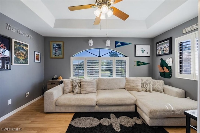 27790 Hacienda E Blvd Unit 206B, Bonita Springs, FL 34135 - living room featuring a tray ceiling, light wood finished floors, a ceiling fan, and baseboards