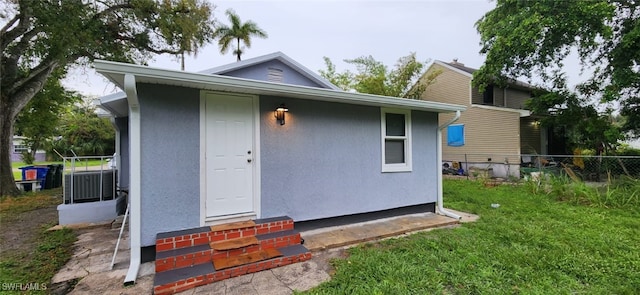 back of house featuring central AC and a yard