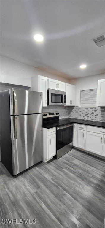 kitchen featuring hardwood / wood-style floors, stainless steel appliances, and white cabinets