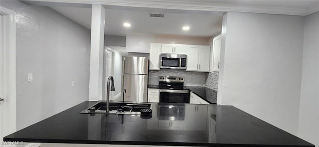 kitchen featuring white cabinets, appliances with stainless steel finishes, decorative backsplash, sink, and crown molding