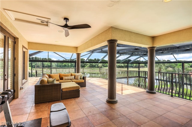 view of patio / terrace featuring a water view, an outdoor living space, ceiling fan, and a lanai