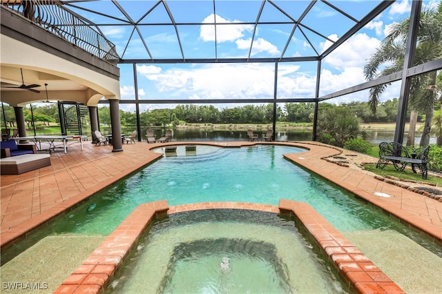 view of pool with glass enclosure, an in ground hot tub, a water view, and a patio