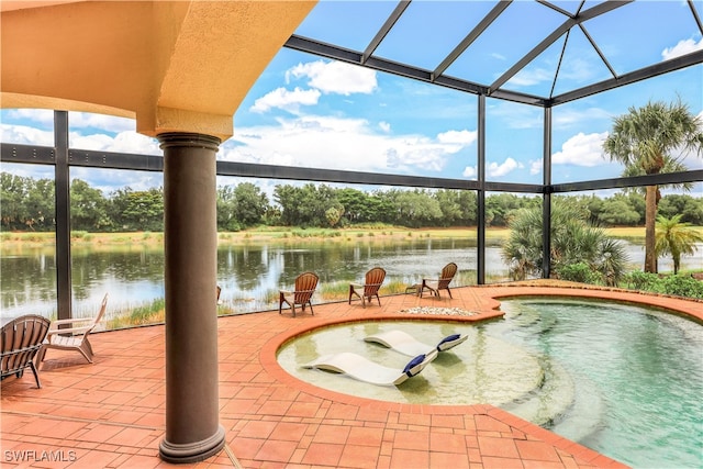 exterior space featuring glass enclosure, a water view, and a patio