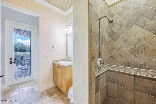 bathroom featuring vanity, crown molding, and tiled shower