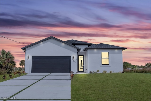 view of front of home with a yard and a garage