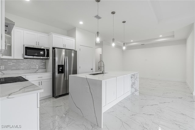 kitchen with sink, hanging light fixtures, a center island with sink, white cabinets, and appliances with stainless steel finishes