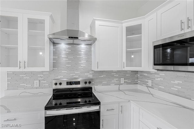 kitchen featuring light stone counters, white cabinetry, exhaust hood, and appliances with stainless steel finishes