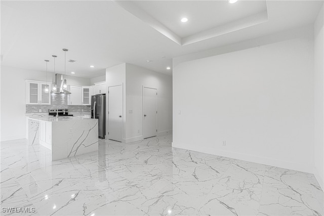 unfurnished living room with a tray ceiling