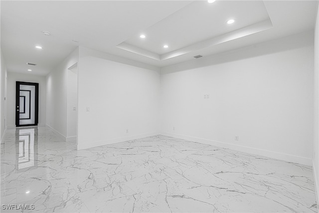 unfurnished room featuring a tray ceiling