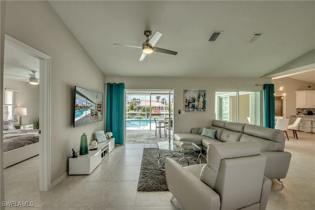 living room featuring ceiling fan, lofted ceiling, and light tile patterned floors