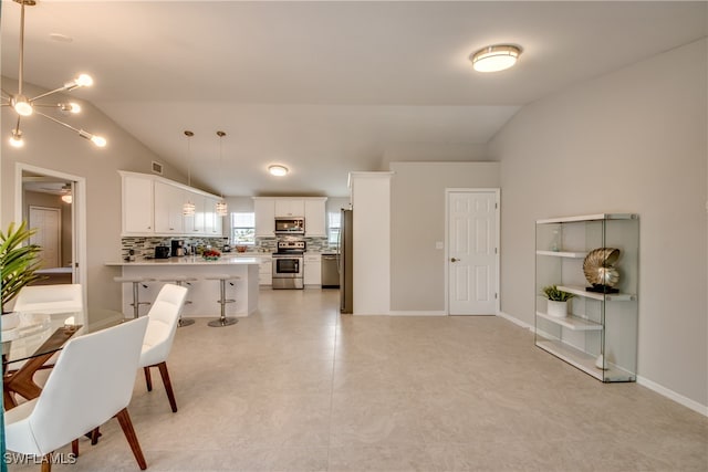 tiled dining room featuring lofted ceiling