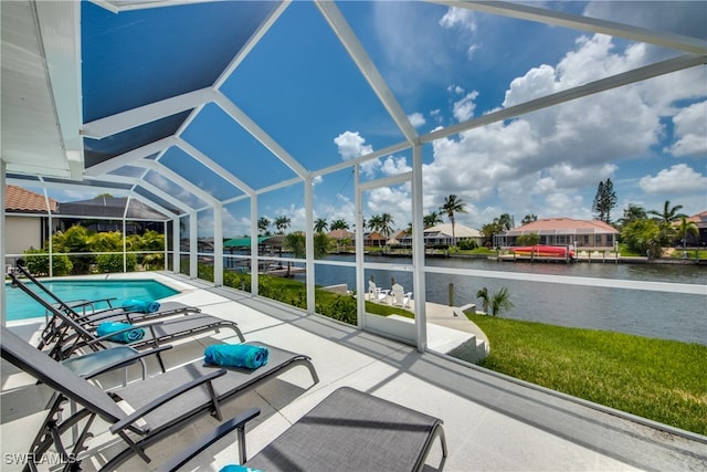 view of swimming pool with a lanai, a patio, and a water view