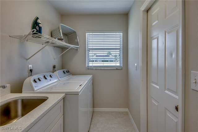 clothes washing area with washer and dryer and sink