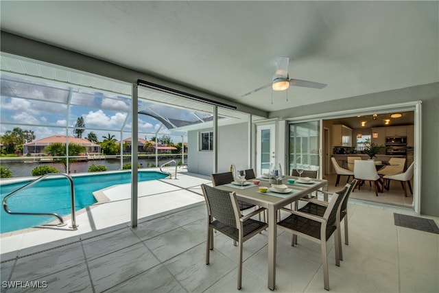 view of swimming pool with ceiling fan and a water view