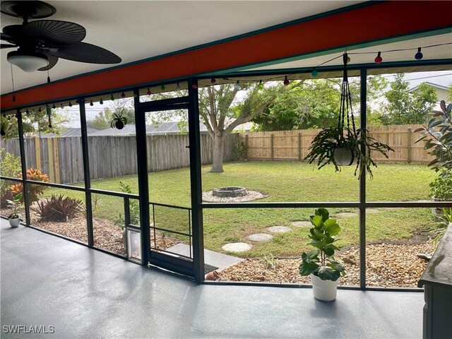 unfurnished sunroom with ceiling fan