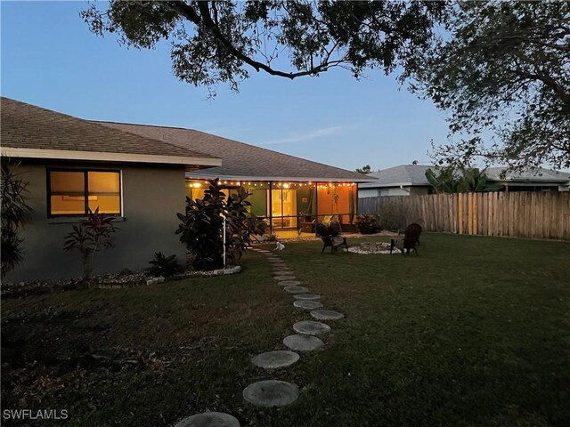 view of yard with an outdoor fire pit and a sunroom