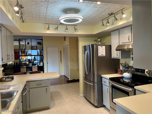 kitchen with gray cabinetry, sink, kitchen peninsula, light tile patterned floors, and appliances with stainless steel finishes