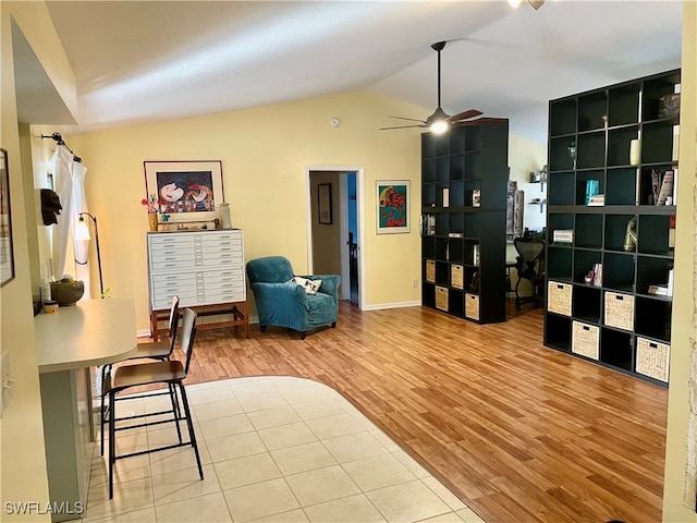 interior space featuring built in shelves, vaulted ceiling, ceiling fan, and wood-type flooring