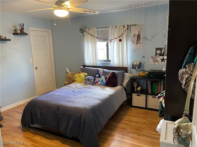 bedroom with a closet, hardwood / wood-style flooring, and ceiling fan