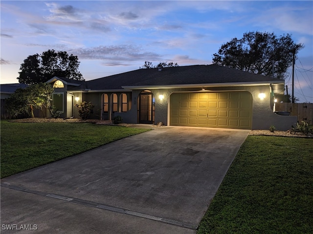 ranch-style house with a garage and a yard