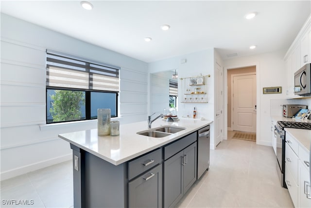 kitchen with a kitchen island with sink, white cabinets, sink, gray cabinets, and stainless steel appliances